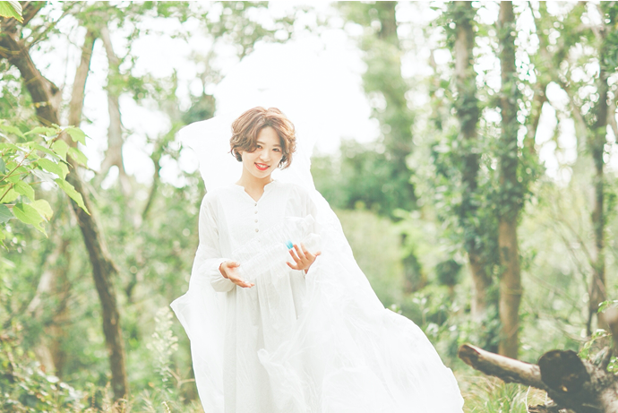 林にたつウェディングドレスを着た女性